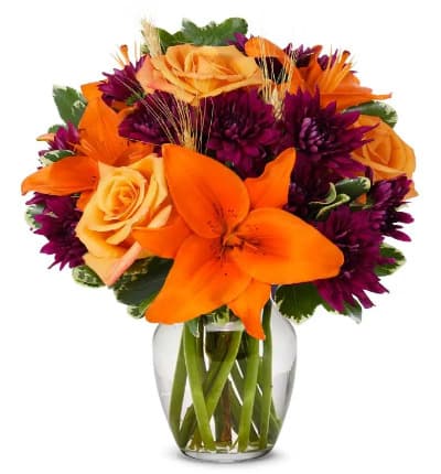 * Orange Roses
* Orange Lilies
* Purple Cushion Poms
* Clear Fluted Vase