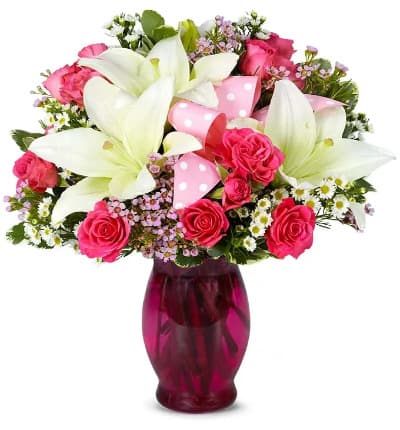 * Pink Spray Roses
* White Lilies
* Pink Waxflower
* White Monte Casino
* Hand Tied Pink Bow
* Keepsake Pink Vase