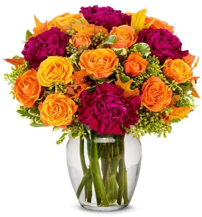 * Orange Spray Roses
* Magenta Carnations
* Solidago
* Clear Glass Vase