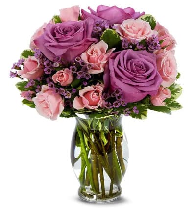 * Purple Roses
* Pink Spray Roses
* Pink Waxflowers
* Seasonal Greens
* Glass Vase